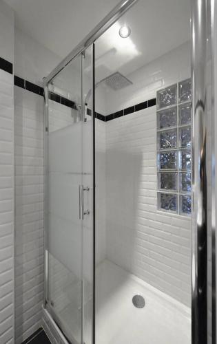 une douche avec une porte vitrée dans une salle de bain dans l'établissement Studio ELLE et LUI Port Nature PN830 - Luxe - 2 personnes, au Cap d'Agde