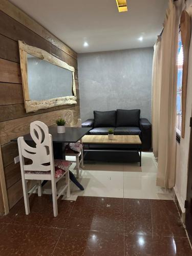 a living room with a couch and a table and chairs at Hostel Gato Colonial in Santo Domingo