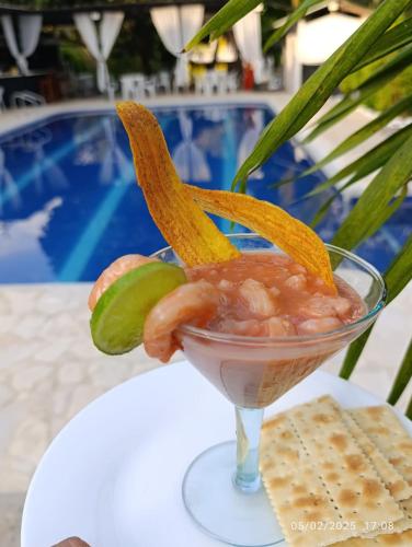 a drink with shrimp and pickles and crackers on a table at hosteria y camping piedras verdes in Sopetran