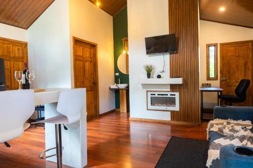 a living room with a couch and a table and a tv at Tierra Buena Countryside Hotel in Monteverde Costa Rica