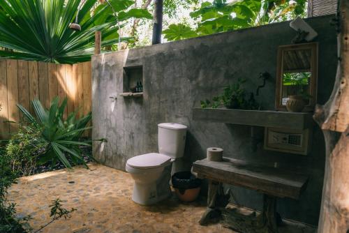 a bathroom with a toilet next to a concrete wall at Isla Fuerte Eco House in Isla Fuerte