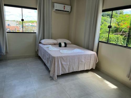 a small bed in a room with two windows at Pousada do Leo in Olinda