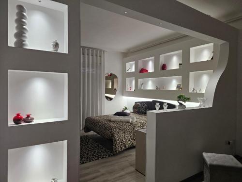 a living room with white shelves and a bed in it at LaBrafa in Comiso