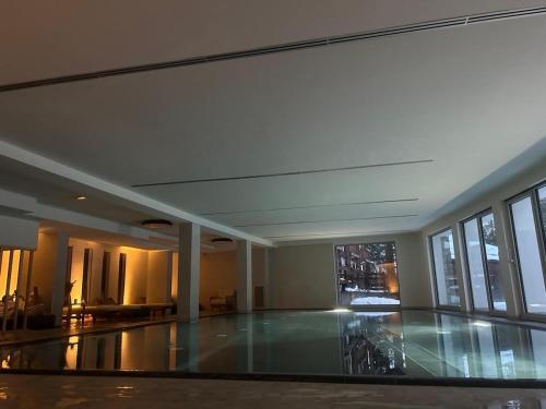 an empty lobby with a large room with glass windows at Maison Du Coeur Champoluc - Spa, Gym e aree relax in Champoluc