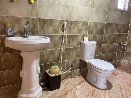 a bathroom with a white toilet and a sink at Dana Sunset Eco Camp in Dana