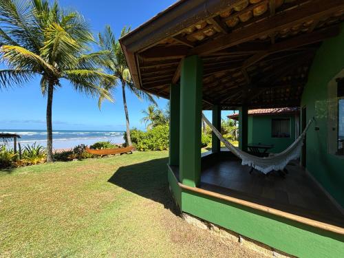 a hammock on the side of a house overlooking the ocean at Casa Del Mar in Marau