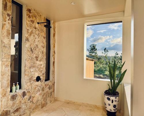 a bathroom with a stone wall and a window at Hidden Valley Wilderness Lodge in San Ignacio