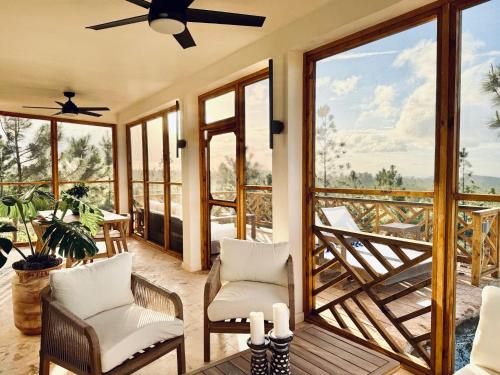 a room with two chairs and a balcony with windows at Hidden Valley Wilderness Lodge in San Ignacio