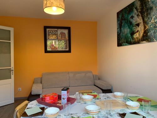 a living room with a table and a couch at Les Amis de Beauval in Seigy