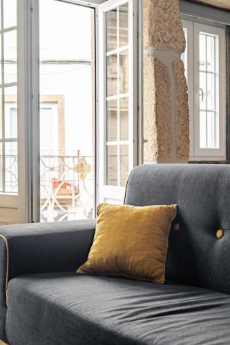 a blue couch with a yellow pillow on it at Ardósia in Vila Real