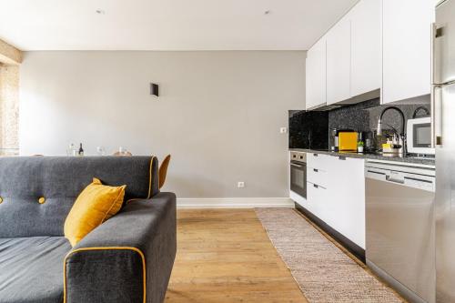 a living room with a couch and a kitchen at Ardósia in Vila Real