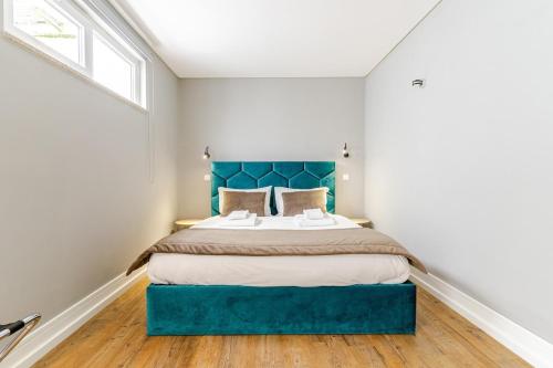 a bedroom with a large bed with a blue headboard at Ardósia in Vila Real