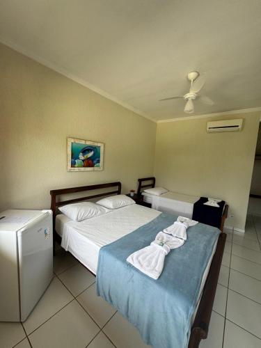 a hotel room with two beds with towels on them at Pousada Marcondes in Paraty