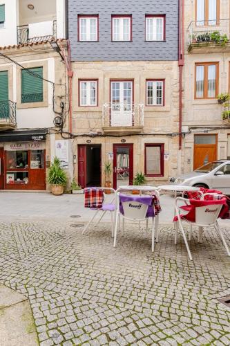 two chairs and a table on a cobblestone street at Ardósia in Vila Real