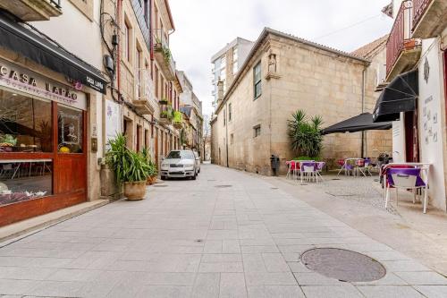 a street in an old town with tables and chairs at Ardósia in Vila Real