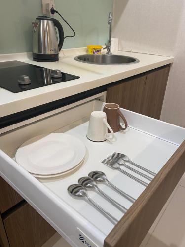 a kitchen counter with a plate and utensils on it at Kozi Square, Kozi 8 in Kuching