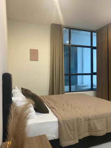 a bedroom with a bed and a large window at Kozi Square, Kozi 8 in Kuching