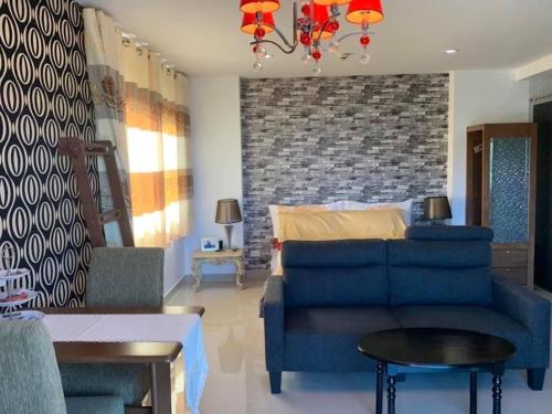 a living room with a blue couch and a bed at Room Mae Phim Beach - Monthly Rent in Chak Phong