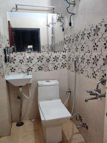 a bathroom with a toilet and a sink and a mirror at SHARVIL Inn in Lucknow