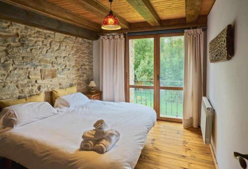 a bedroom with a teddy bear laying on a bed at Casa Pirineos ambos apartamentos in Ulle