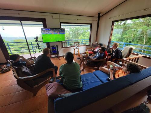 a group of people sitting in a room watching tv at Volcano Panoramic Views in Vara Blanca