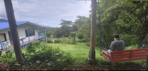 a man sitting on a swing in a garden at Volcano Panoramic Views in Vara Blanca