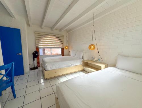 a bedroom with two beds and a blue door at Castillos Del Mar in Rosarito