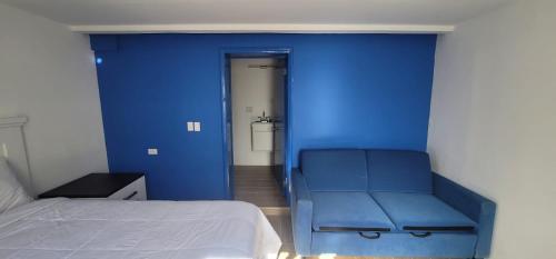 a blue room with a bed and a blue wall at Castillos Del Mar in Rosarito