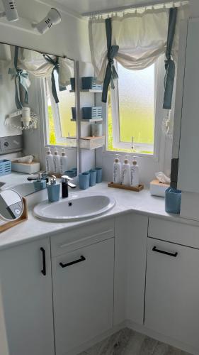 a white bathroom with a sink and a window at Biały domek in Zastań