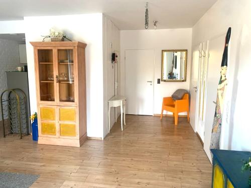 a living room with a wooden floor and a cabinet at Großartige Wohnung mit großem Garten in Bad Schwartau! in Bad Schwartau