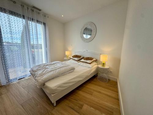 - une chambre avec un lit, deux lampes et un miroir dans l'établissement Maison Neuve 5 Personnes - Proche de la Mer - EXT, à La Tranche-sur-Mer