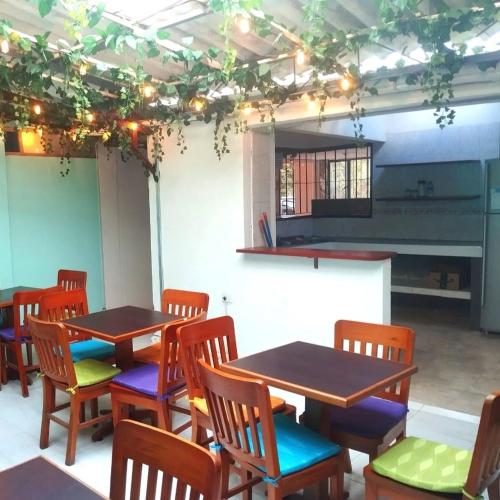 a room with tables and chairs and a piano at Hostal las margaritas in Pasto