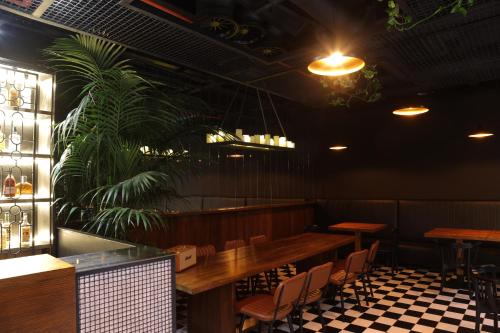 a restaurant with tables and chairs and a plant at Hotel Twenties Tbilisi - Stay & Dine in Tbilisi City
