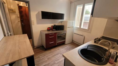 - une cuisine avec un évier au milieu d'une pièce dans l'établissement Bel appartement de 50m2 au calme, à Nîmes