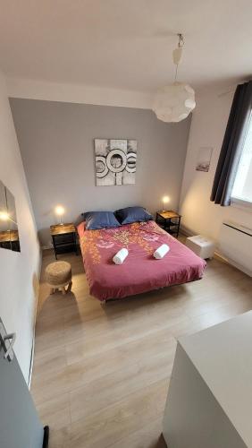 une chambre avec un grand lit avec une couverture rouge dans l'établissement Bel appartement de 50m2 au calme, à Nîmes