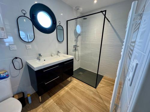 une salle de bain avec une douche, un lavabo et un miroir dans l'établissement House Neuve 4 People - Close to La Mer - EXT, à La Tranche-sur-Mer