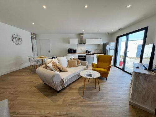 un salon avec un canapé et une table dans l'établissement House Neuve 4 People - Close to La Mer - EXT, à La Tranche-sur-Mer