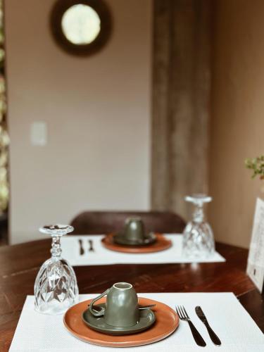 a table with two plates and glasses on a table at Vila Abaton in Alto Paraíso de Goiás