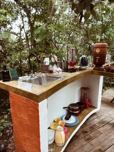 a kitchen counter with a sink and some pots and pans at Vila Abaton in Alto Paraíso de Goiás