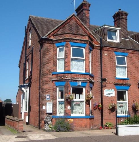 a brick house with blue trim on a street at Spindrift Guest house in Great Yarmouth