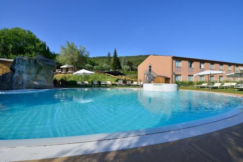a large swimming pool with a waterfall in a resort at La Meridiana Bleisure Hotel in Perugia