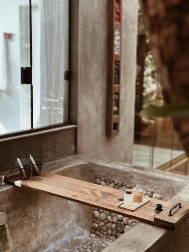a bathtub with a wooden tray and a cup of coffee at Vila Abaton in Alto Paraíso de Goiás
