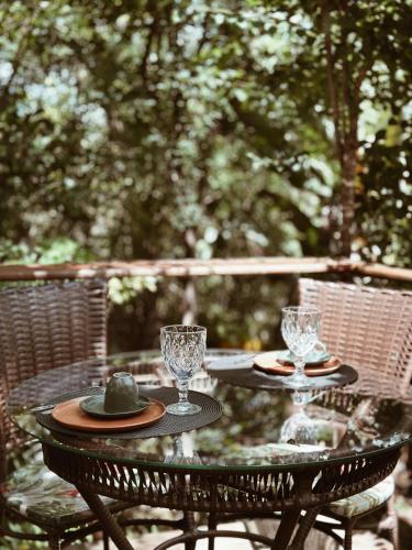 a table with two plates and glasses on it at Vila Abaton in Alto Paraíso de Goiás