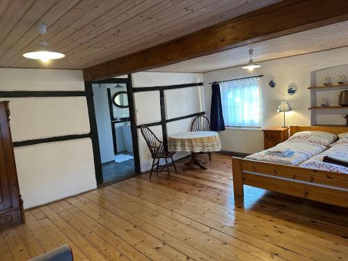 a bedroom with a bed and a table in it at Agroturystyka Zacisze in Maciejowiec