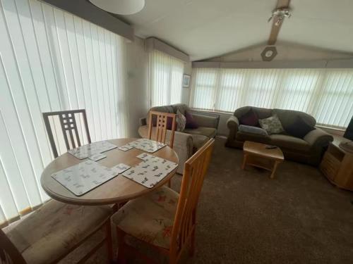 a living room with a table and a couch at 6 Berth Caravan Skegness Highfields and the Haven in Winthorpe