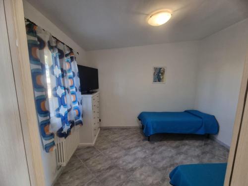 a small room with a blue bed and a tv at Il Gelso in Lecce