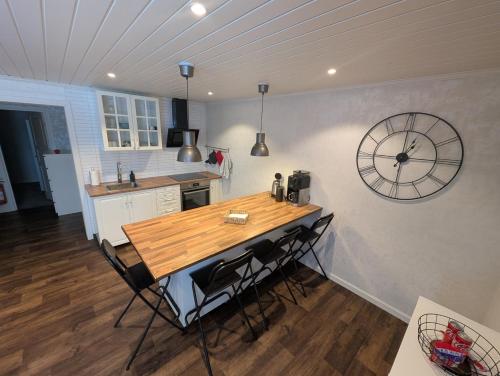 a kitchen with a table and a clock on the wall at Guesthouse Olivier in Hammarstrand