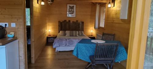 une chambre avec un lit et une table dans une pièce dans l'établissement Cabanes des Pins Sylvestres Gélas, à Saint-Martin-Vésubie