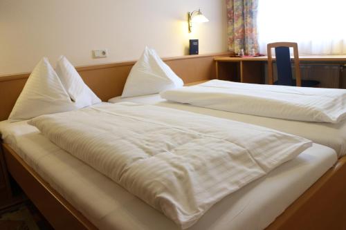 two beds in a room with white sheets and pillows at Gasthof Bokan in Graz