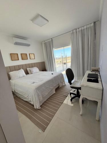 une chambre avec un lit, un bureau et un ordinateur dans l'établissement Casa da Mãe São Pedro, à São Pedro da Aldeia